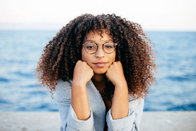 Portrait of beautiful young woman with sea in background