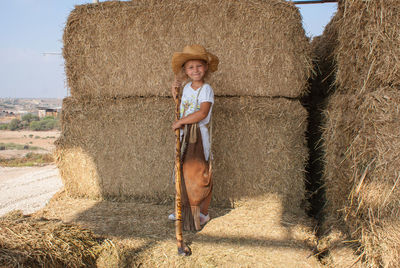 Portrait of smiling girl standing on hay