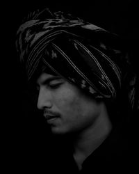 Portrait of young man against black background