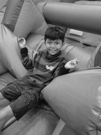 High angle view of boy sitting on bed at home