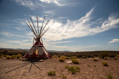 Traditional windmill on field against sky