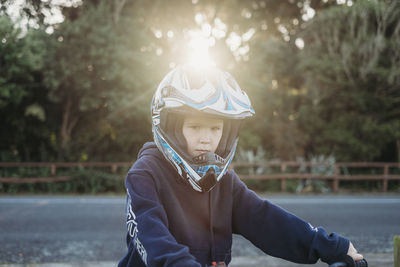 Young boy wearing motorbike helmet looking at the camera