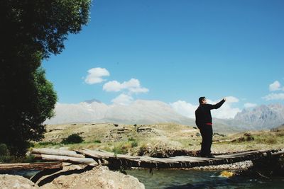 Man standing on mountain against sky