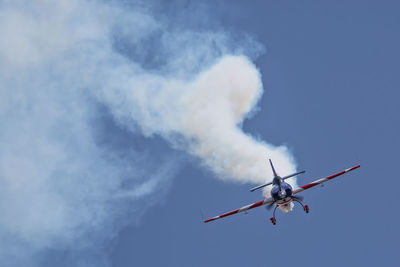 Smoke emitting from military airplane against sky