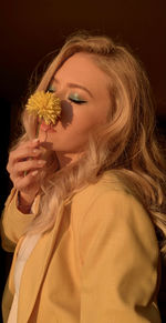 Portrait of beautiful woman holding flower head