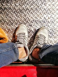 Low section of man standing on tiled floor