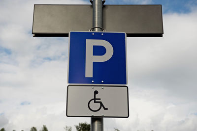 Low angle view of road sign against sky