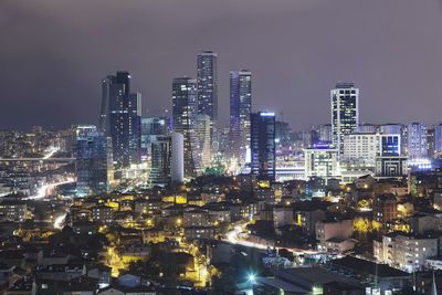 Illuminated city against sky at night