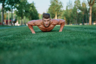 Portrait of young woman exercising on field