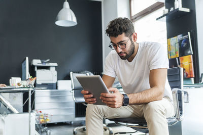 Young man looking at tablet in a modern office