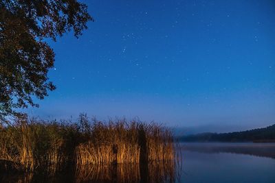 Scenic view of lake against sky at night