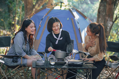 Three bestie go camping in the forest and take a photos while cooking