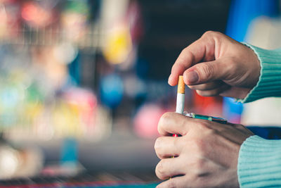 Close-up of hand holding cigarette