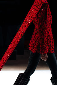 Low section of woman standing against black background
