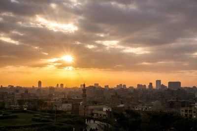 View of cityscape against cloudy sky during sunset