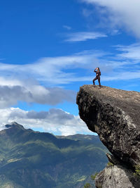 Woman standing on mountain cliff