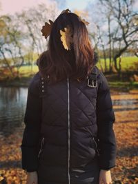 Midsection of woman standing by tree