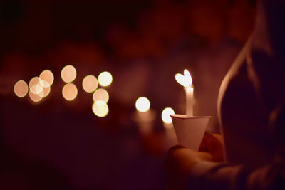 Midsection of woman holding burning candle