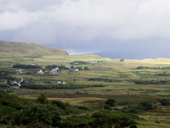 Scenic view of green landscape and mountains against sky