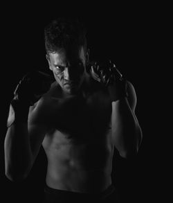 Shirtless boxer against black background