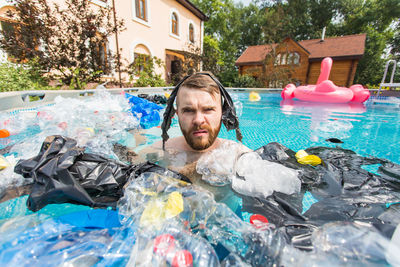 Portrait of man floating on swimming pool