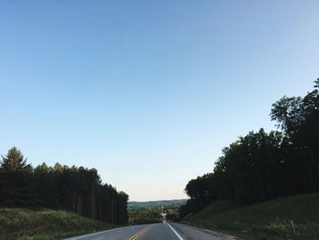 Empty road along trees