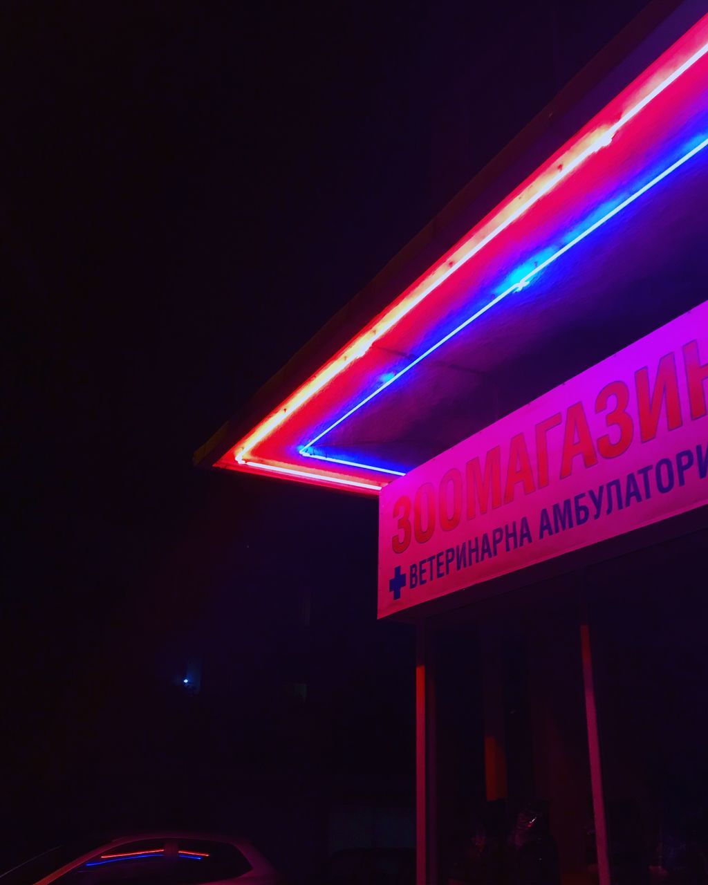 LOW ANGLE VIEW OF ILLUMINATED ROAD SIGN AT NIGHT