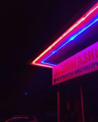 Low angle view of illuminated sign on road at night