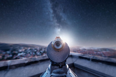 Close-up of coin-operated binoculars against buildings in city