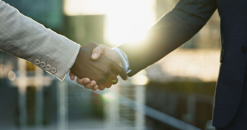 Midsection of businessman shaking hands