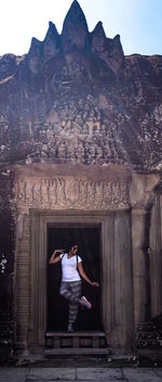 Woman standing outside temple against building