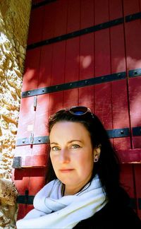 Portrait of smiling woman standing against brick wall