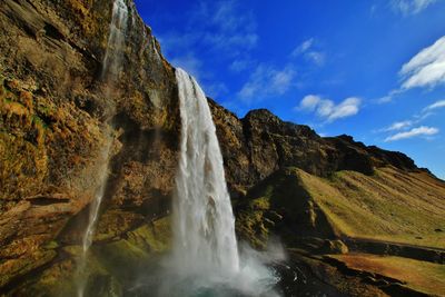 Scenic view of waterfall against sky