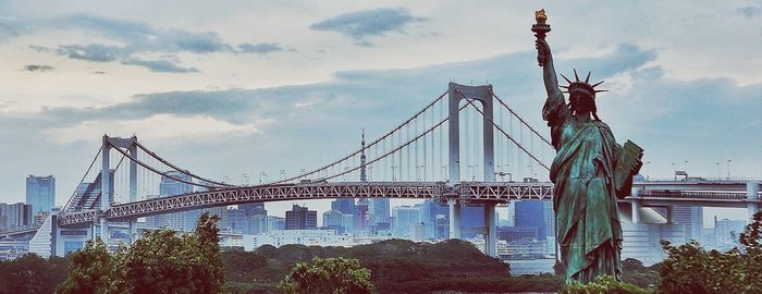 Low angle view of bridge against cloudy sky