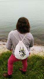 Rear view of boy standing in sea