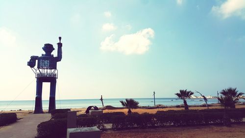 Man standing on beach against cloudy sky