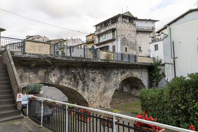 Bridge by buildings against sky in city