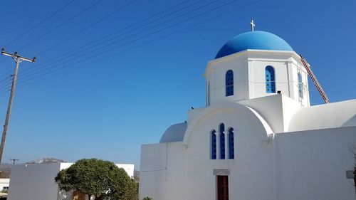 Low angle view of church and building against clear blue sky