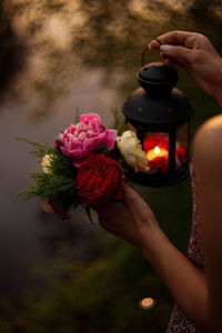 Midsection of person holding red rose flower
