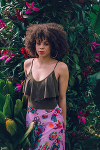 Young woman standing by plants