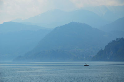 Scenic view of sea and mountains against sky