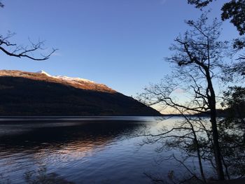 Scenic view of lake and mountains against blue sky