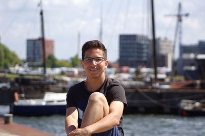 Portrait of smiling young man against boat in sea