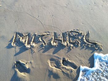 High angle view of text on sand