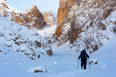 People walking on snowcapped mountain during winter