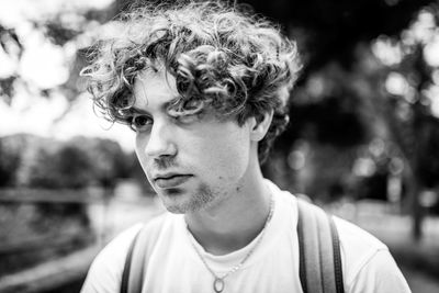 Portrait of young man looking away outdoors