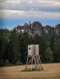 Lifeguard hut on field against trees