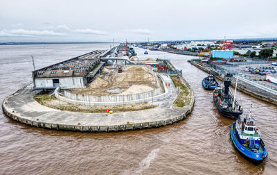 High angle view of city by sea against sky