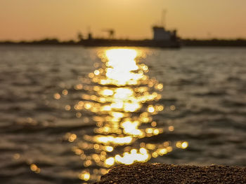 Reflection of illuminated sea against sky during sunset