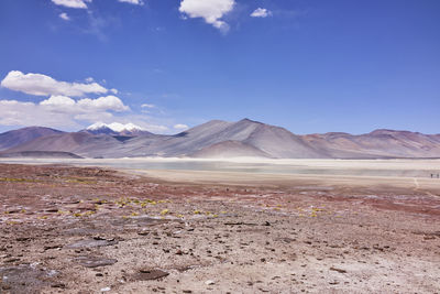 Scenic view of mountains and slat flat against blue sky